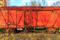 Rusty red metal freight car on disused train tracks at old station Royalty Free Stock Photo