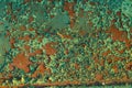 Rusty red metal wall weth peeling flakes of lime green paint tex Royalty Free Stock Photo