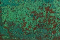 Rusty red metal wall weth peeling flakes of lime green paint tex Royalty Free Stock Photo