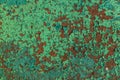 Rusty red metal wall weth peeling flakes of lime green paint tex Royalty Free Stock Photo