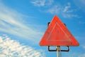 Rusty red warning triangle sign under blue sky with clouds Royalty Free Stock Photo