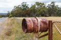 Rusty rural barrel letterbox on farm gate