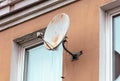 Rusty satellite dish on the wall of the house Royalty Free Stock Photo