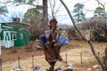 A rusty sculpture of an elf playing a horn in the garden surrounded by bare winter trees, yellow winter grass with gray sky Royalty Free Stock Photo