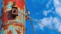 Rusty seaside crane pulley, blue sky background Royalty Free Stock Photo