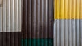 Rusty sheets of corrugated iron in different colors. Texture background of brown, gray, yellow, green corrugated fence. Colorful Royalty Free Stock Photo