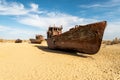 rusty ship at the bottom of the former Aral Sea. The dried-up sea in an environmental disaster and climate change in Royalty Free Stock Photo
