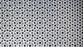 Rusty silver metal background with round holes. Metal texture with holes. Iron gray perforated background. Steel durable