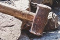 Rusty sledgehammer on broken bricks and concrete stones