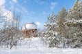 Rusty spherical gas tank in forest