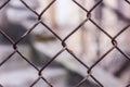 Rusty steel chain link or wire mesh as boundary wall. There is still concrete block wall behind the mesh.