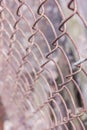 Rusty steel chain link or wire mesh as boundary wall. There is still concrete block wall behind the mesh.