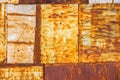 rusty steel sheets welded together wall patchwork with leftovers of faded white paint, closeup full-frame background and Royalty Free Stock Photo