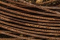 Rusty surface of iron wire macro photo. Abstract grunge background in red-brown color coiled rusty wire