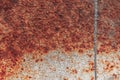 Rusty surface with red-brown shades, and a vertical strip of gray paint