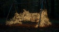 Rusty swing set engulfed in a thousand warm lights Royalty Free Stock Photo