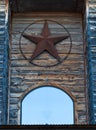 Rusty Texas star hanged on wooden building facade