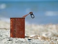 Rusty tin can on the beach with blue sea Royalty Free Stock Photo