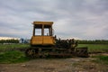 Rusty tractor on tracks in the field Royalty Free Stock Photo