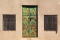 Rusty traditional Oman door on Jabal Shams that was formerly green, along with two windows