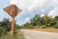 Rusty traffic sign on country road  on blue sky background Royalty Free Stock Photo