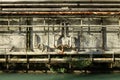 Rusty tubes and pipes on the wall of a dismissed factory. Railing and river in front. Royalty Free Stock Photo