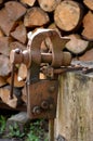 A rusty vice located outside on a stump is used to grip objects for work, also to sharpen a hand scythe. Royalty Free Stock Photo