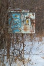 A rusty vintage old phone box I think on a pole that no longer had a phone in it - next to remote area railroad tracks - cold sn