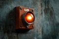 Rusty wall-mounted alarm with red light in industrial setting Royalty Free Stock Photo