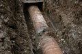 Rusty water pipeline in the trench ground view