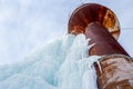 Rusty water tower covered with blue ice at winter time Royalty Free Stock Photo