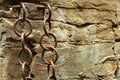 Rusty weathered iron chains shackled to rocks