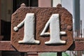 A rusty and weathered red and brown house number plaque Royalty Free Stock Photo