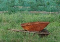 Rusty wheelbarrow in tall grass