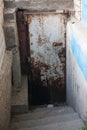 Rusty white iron door to the basement from the street. Emergency exit