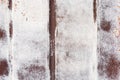 Rusty metal garage wall with brushstrokes of paint and vertical stripes