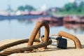 Rusty wire rope padlocked to a concrete block. Close up. Royalty Free Stock Photo