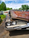 Rusty wrecked forgotten car in a junkyard