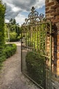 Rusty wrought iron gate opening into walled garden Englan Royalty Free Stock Photo