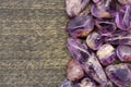 Rutilated amethyst jewel heap on black wood half background. Place for text