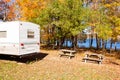 RV camped in fall forest on lakeshore campsite