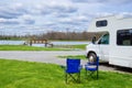 RV camper and chairs in camping, family vacation travel, trip in motorhome Royalty Free Stock Photo