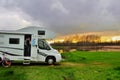 RV camper and woman in camping on sunset, family vacation travel, holiday trip in motorhome Royalty Free Stock Photo