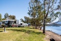 RV caravans camping at the caravan park on the lake with mountains on the horizon. Camping vacation travel concept