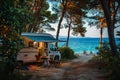 RV motorhome camping spot by the beach at dusk with string lights and tranquil sea view Royalty Free Stock Photo