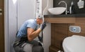 RV Rentals Worker Cleaning Shower Cabin Inside a Camper Van Motorhome