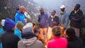 Group of diverse people around the bonfire discussing a plan for trekking in the mountains