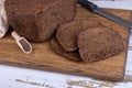 Rye Borodino (Borodinskiy) bread with a crispy crust on a wooden board, cut into slices. Homemade baking. Royalty Free Stock Photo