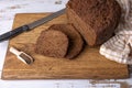 Rye Borodino (Borodinskiy) bread with a crispy crust on a wooden board, cut into slices. Homemade baking. Royalty Free Stock Photo