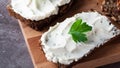 Rye bread with cream cheese on grey table. Whole grain rye bread with seeds.